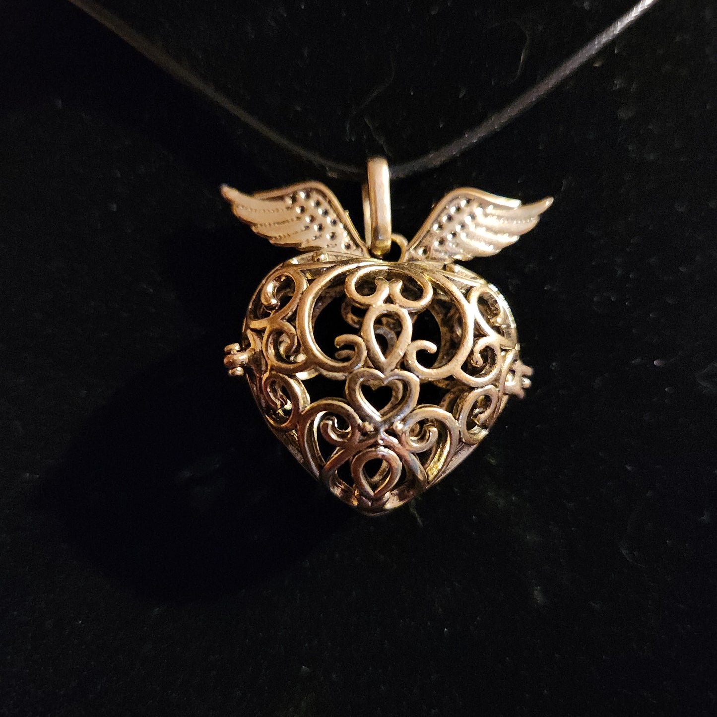 Gold tone heart with wings locket/cage necklace