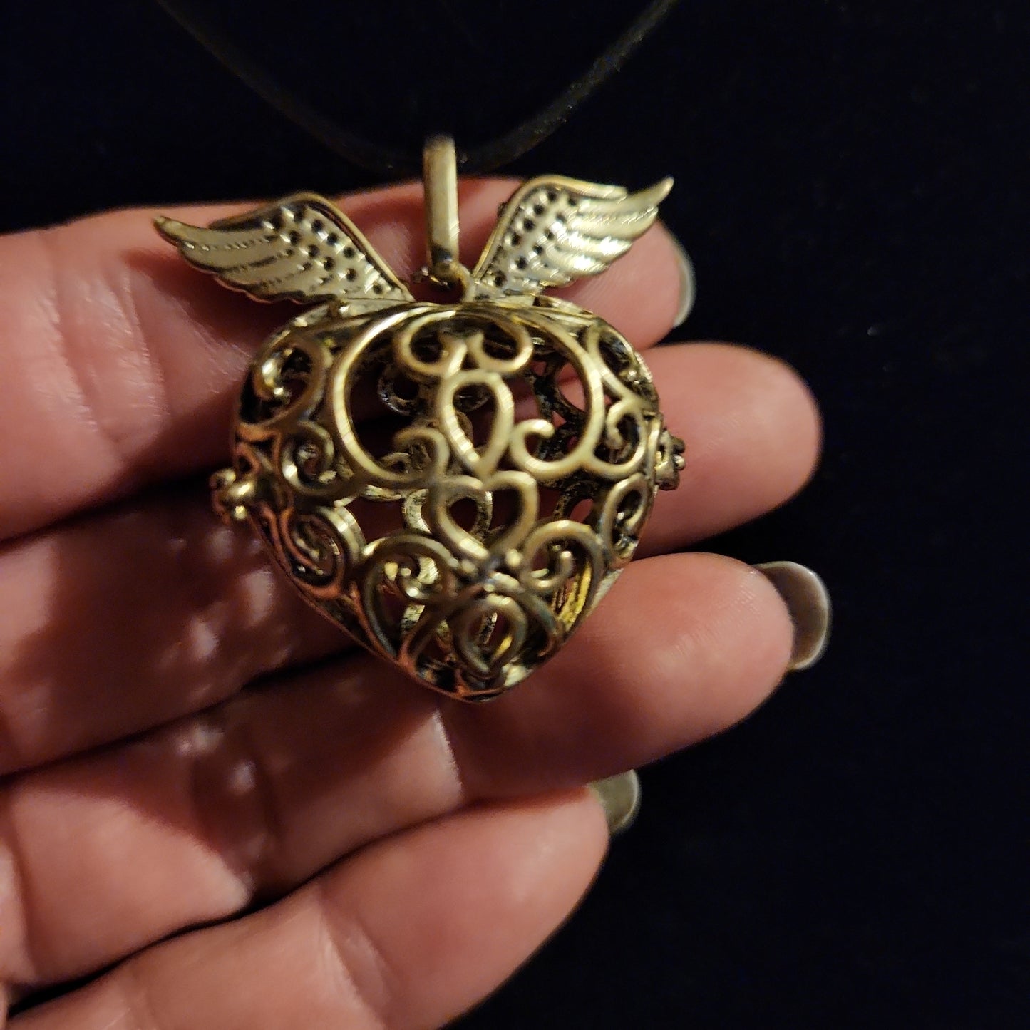 Gold tone heart with wings locket/cage necklace
